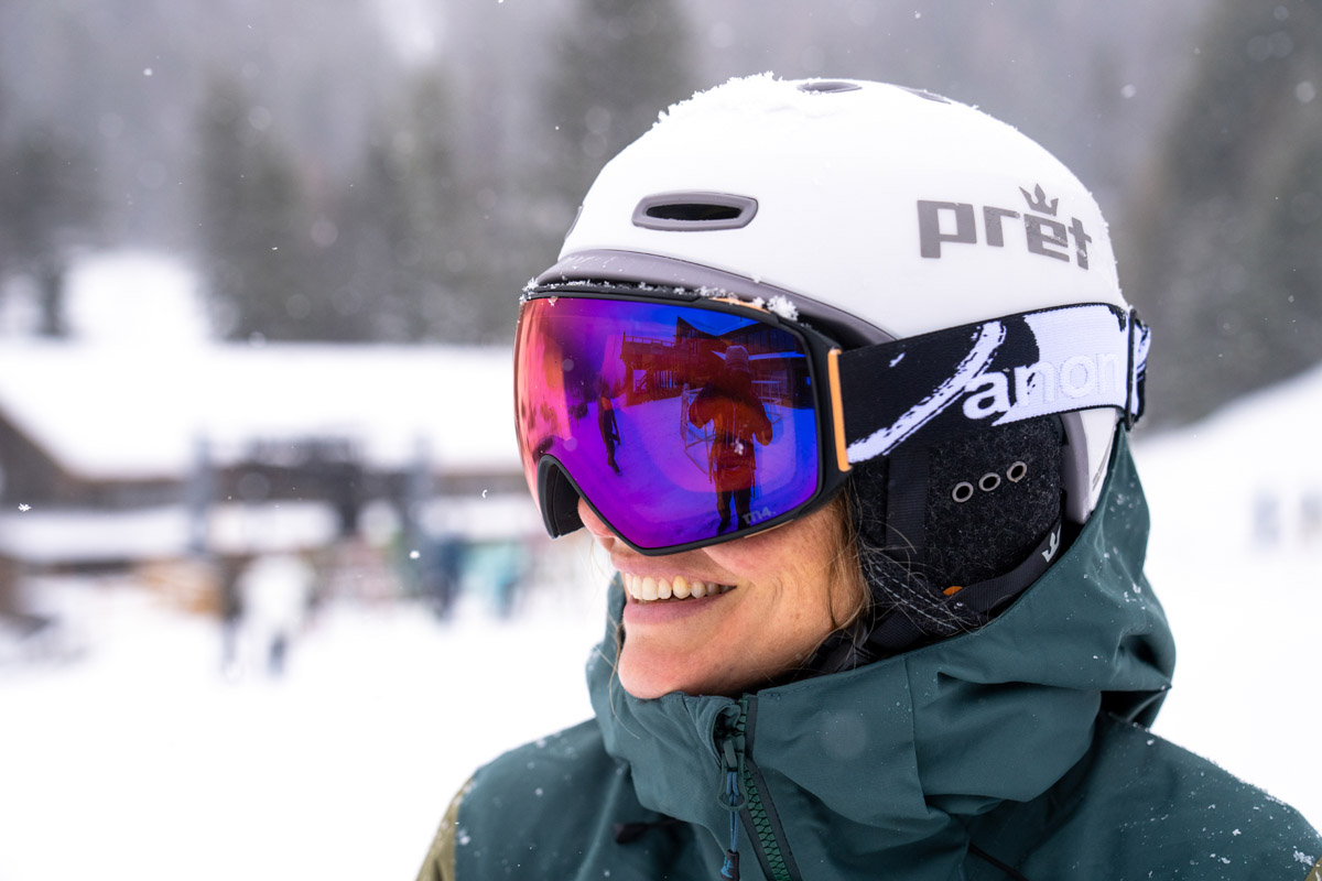 A woman wearing a white ski helmet with goggles