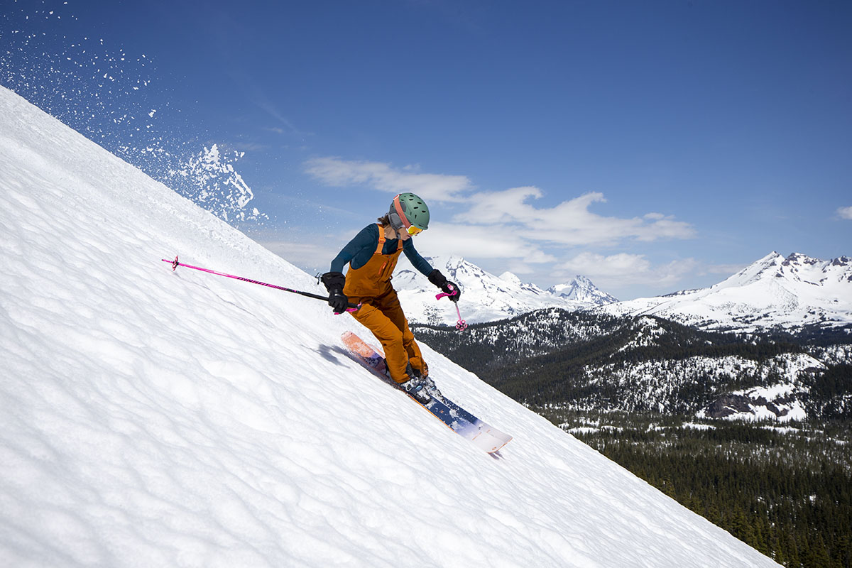 A woman skis down a very steep hill in the Trew Gear Chariot Bib Primo