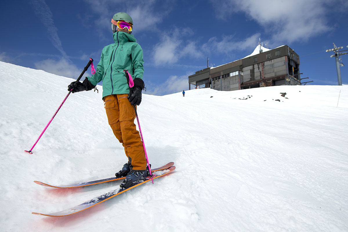A woman standing with skis and ski poles
