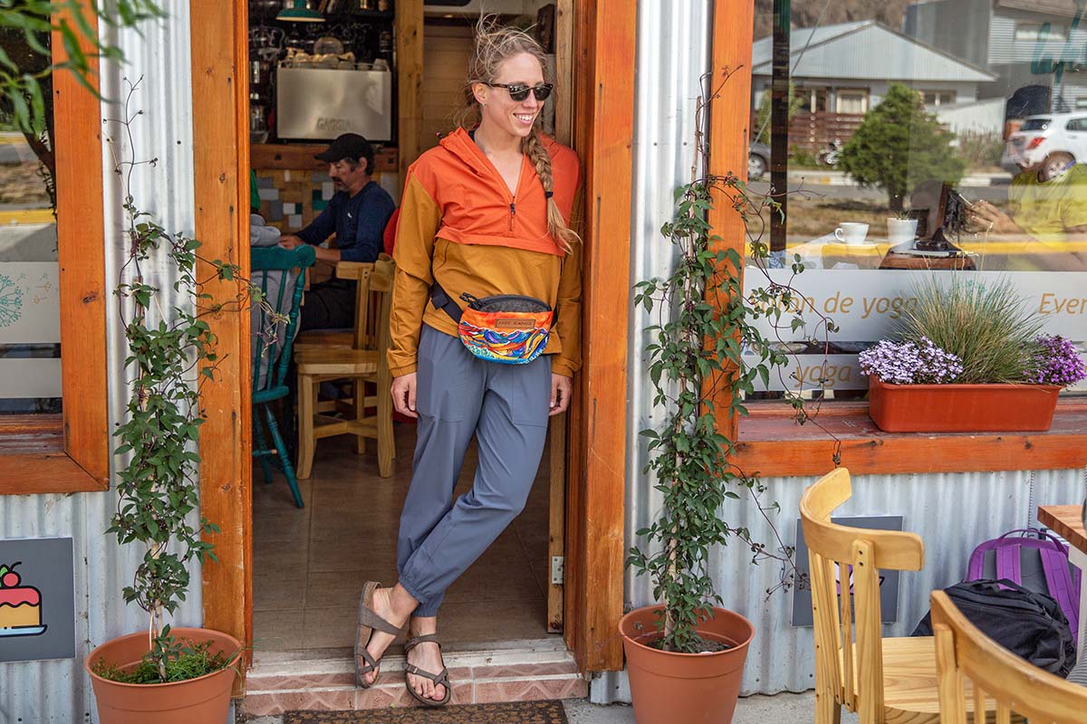 A woman smiles and stands in the doorway of a cafe