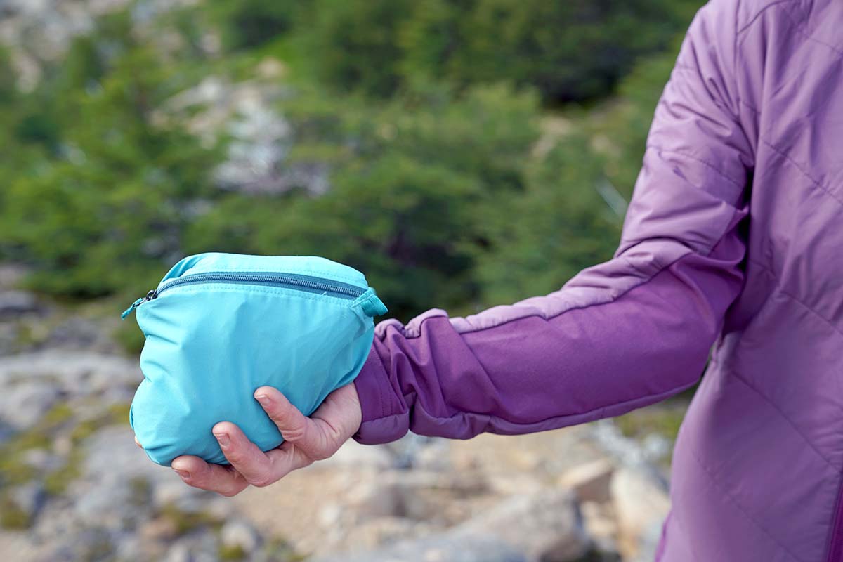 holding a jacket folded into its own pocket