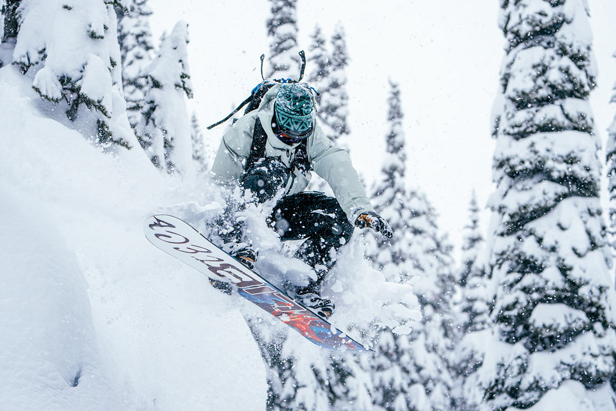 A snowboarder doing a trick in the powder