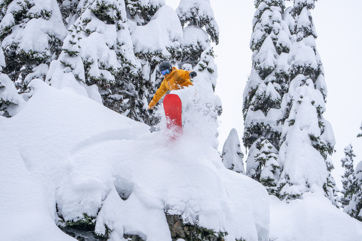 A snowboarder catching air off a cliff