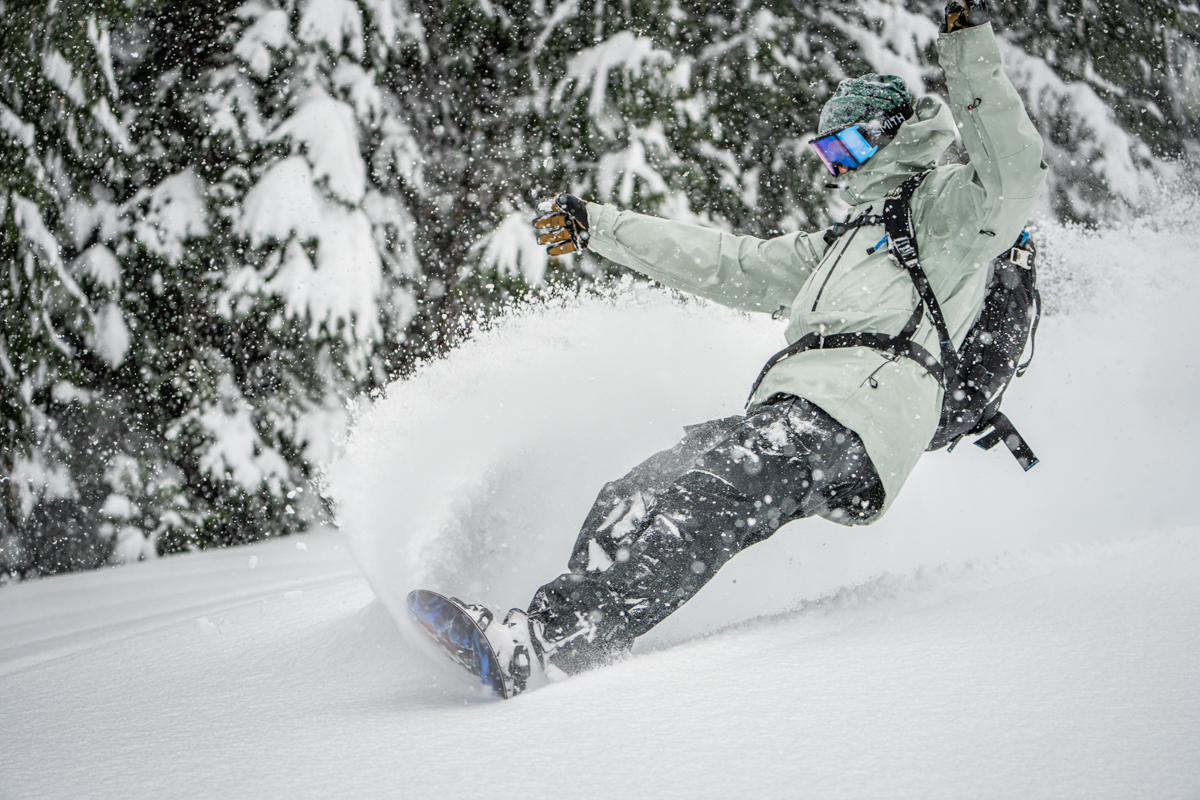 A snowboarder doing an epic slash in the powder