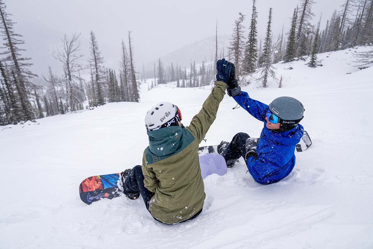 Sitting while snowboarding and high fiving