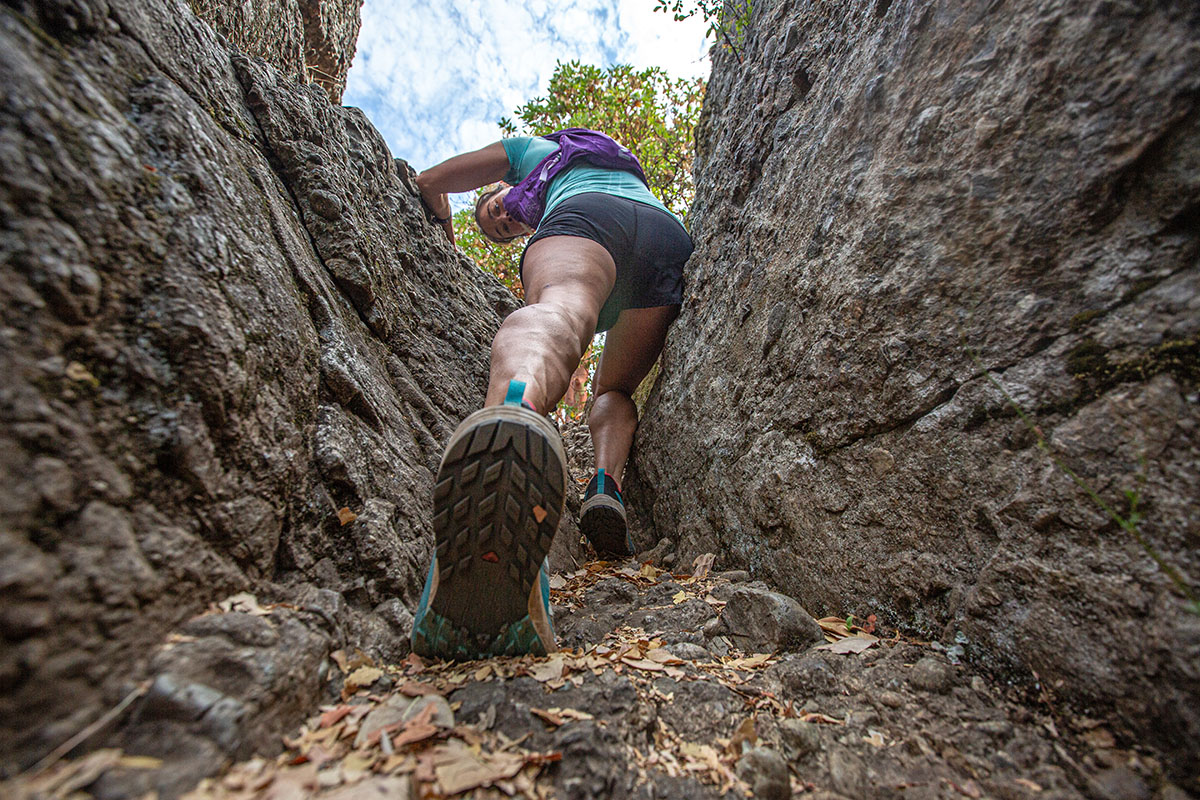 A closeup shot of a shoe outsole while hiking through rocks
