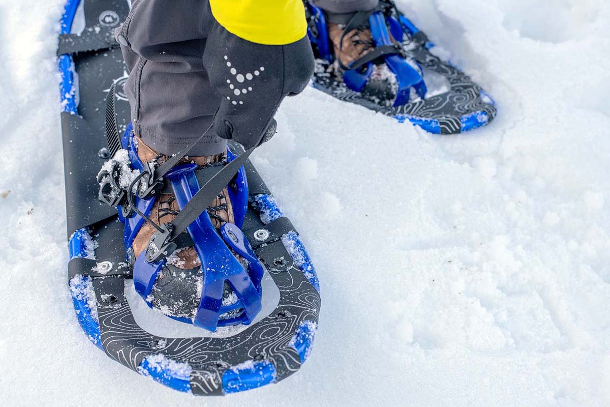 Adjusting the bindings on blue snowshoes