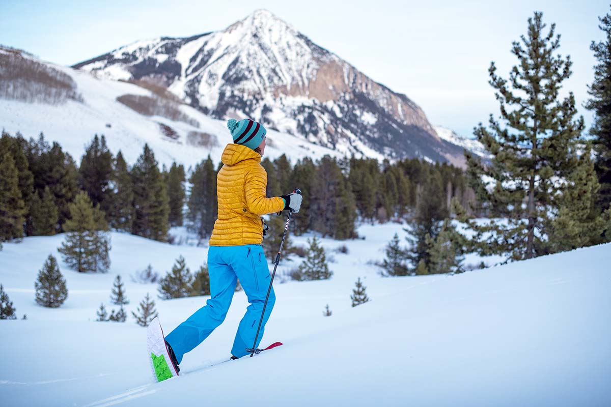 A woman hiking in the mountains with snowshoes