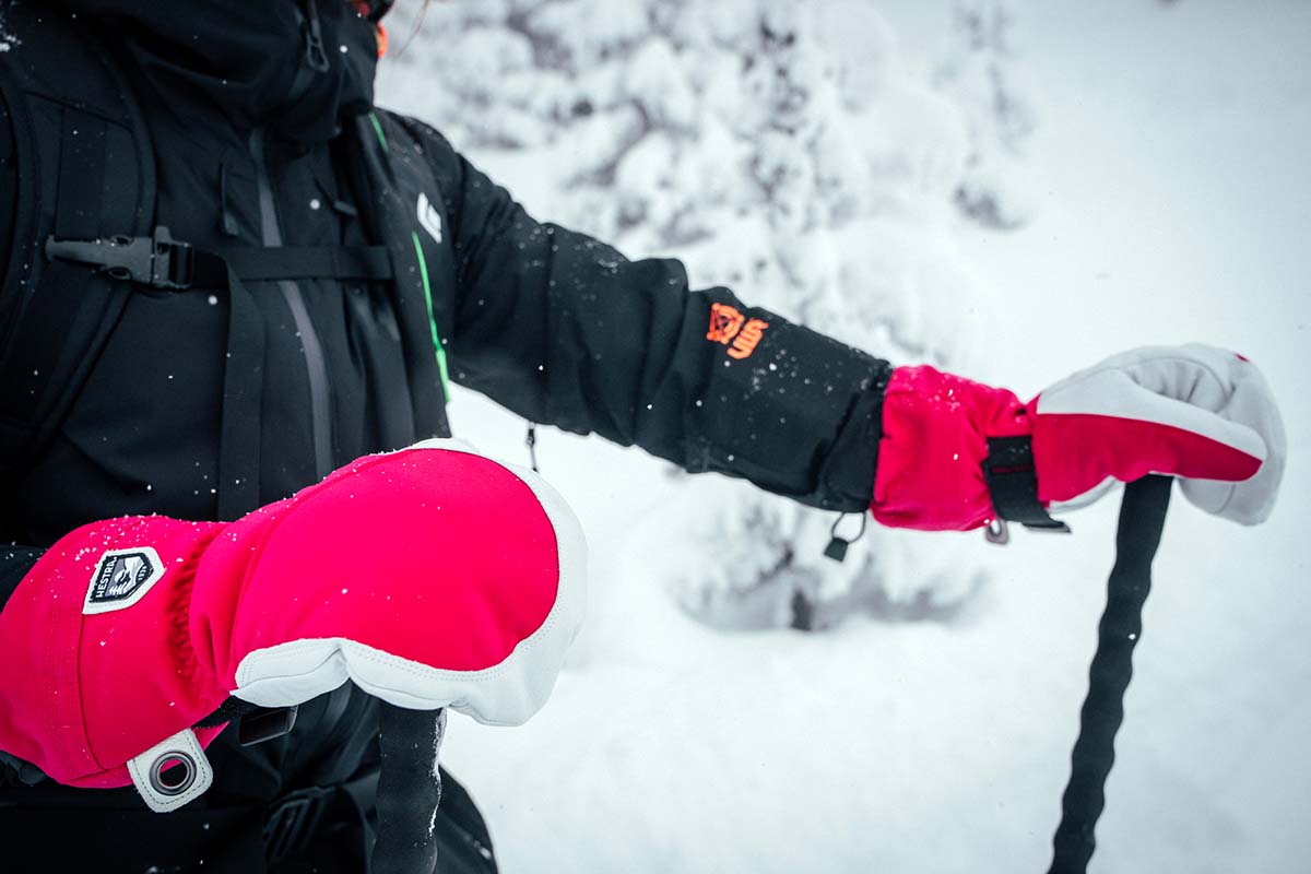 Pink winter mittens holding onto ski poles