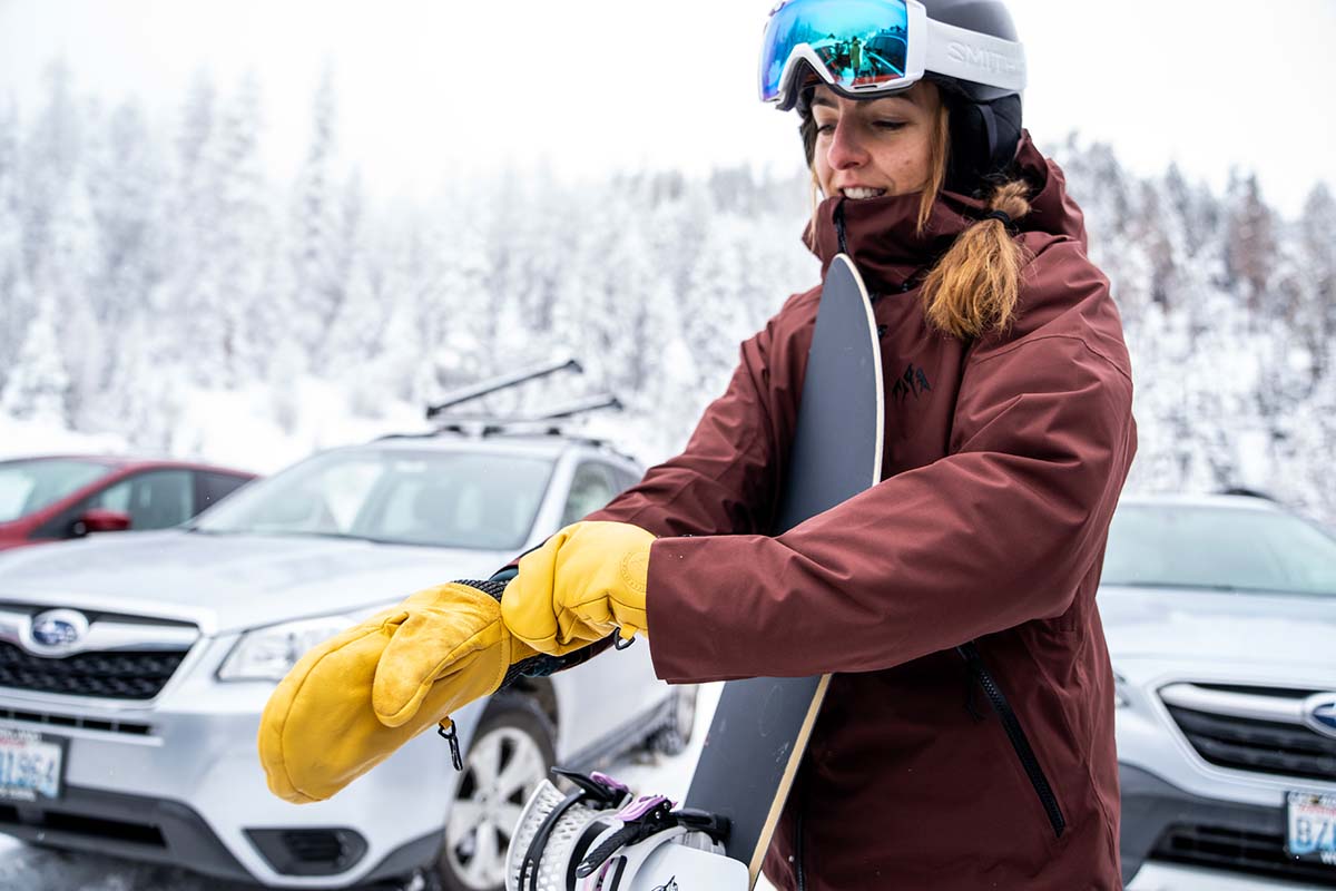 A woman putting on leather winter mittens