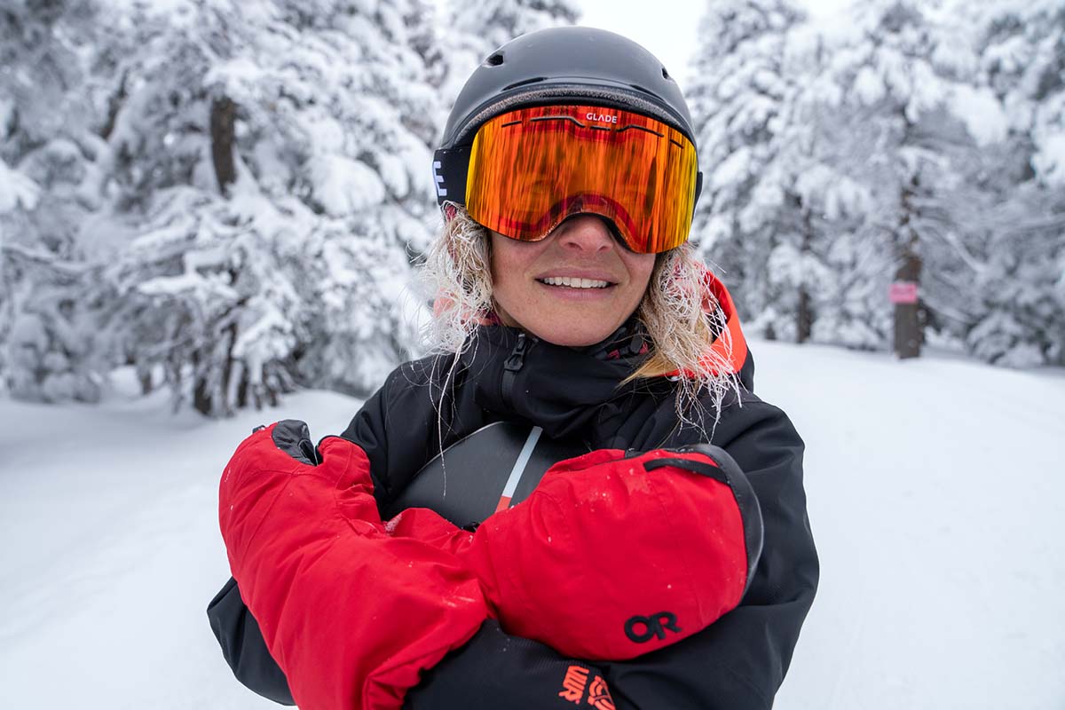 A woman holding red winter mittens over her chest