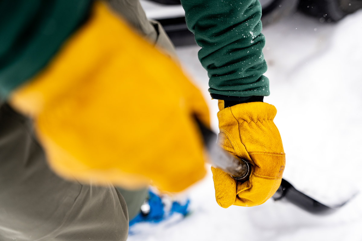 Close up of winter mittens on a shovel handle
