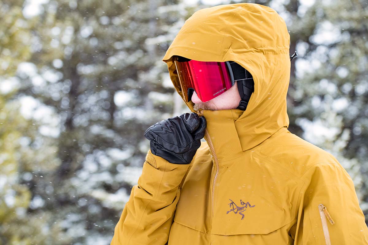 Zipping up a hardshell jacket while out in the snow skiing