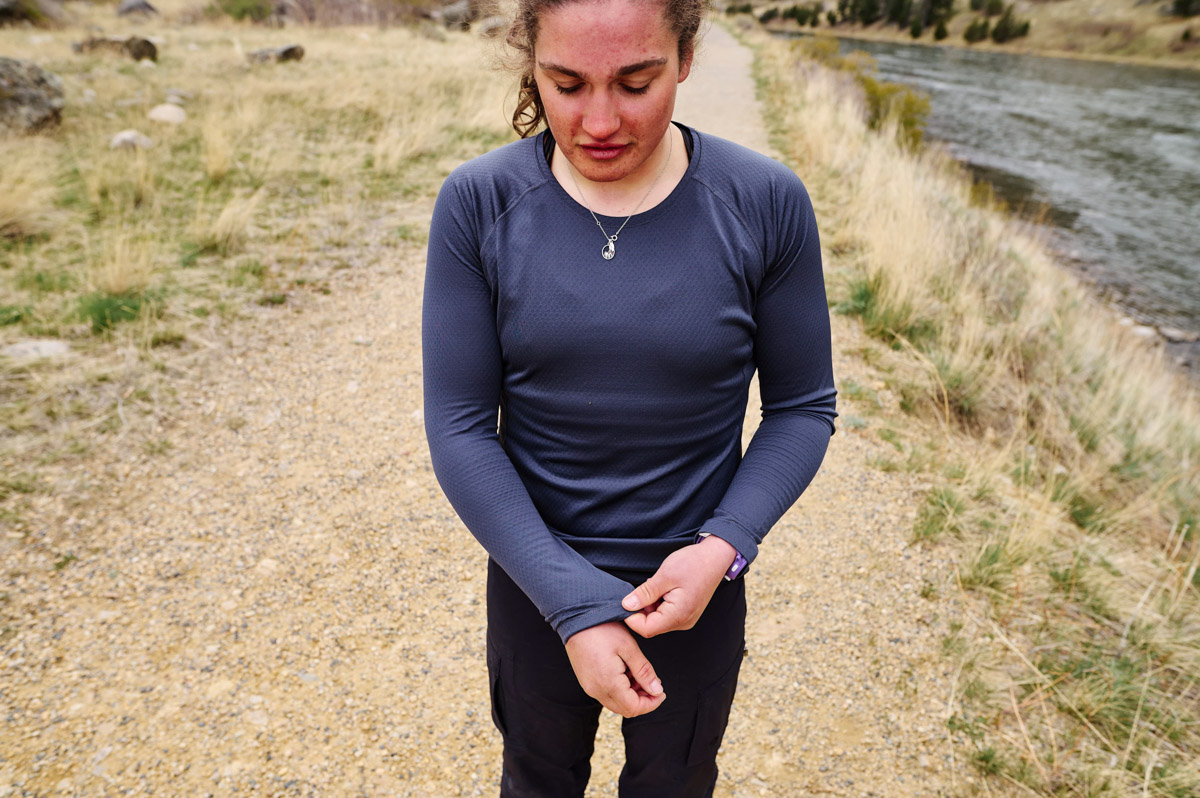 A woman pulls the sleeve down on her blue baselayer