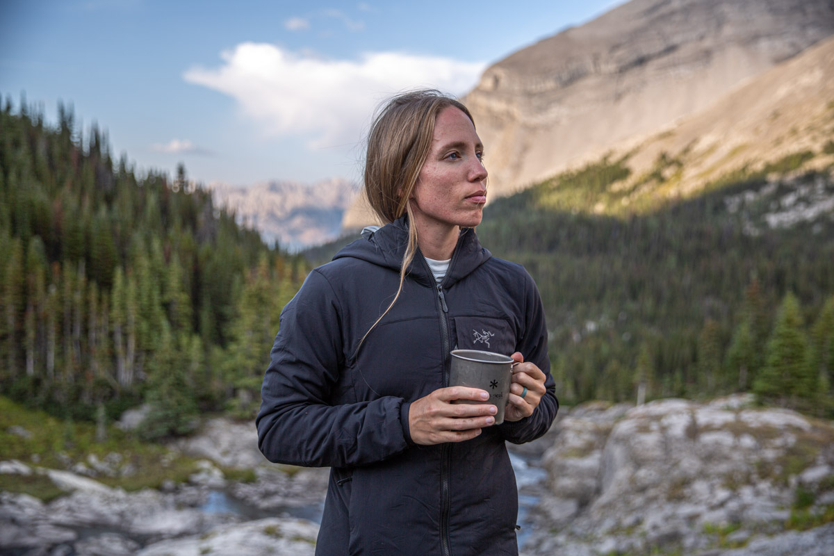 A woman standing in a black midlayer and white baselayer