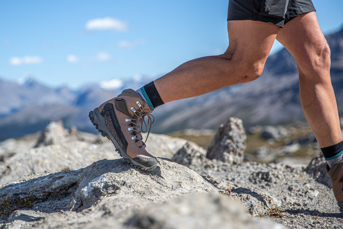 A hiking boot mid-step on a rock