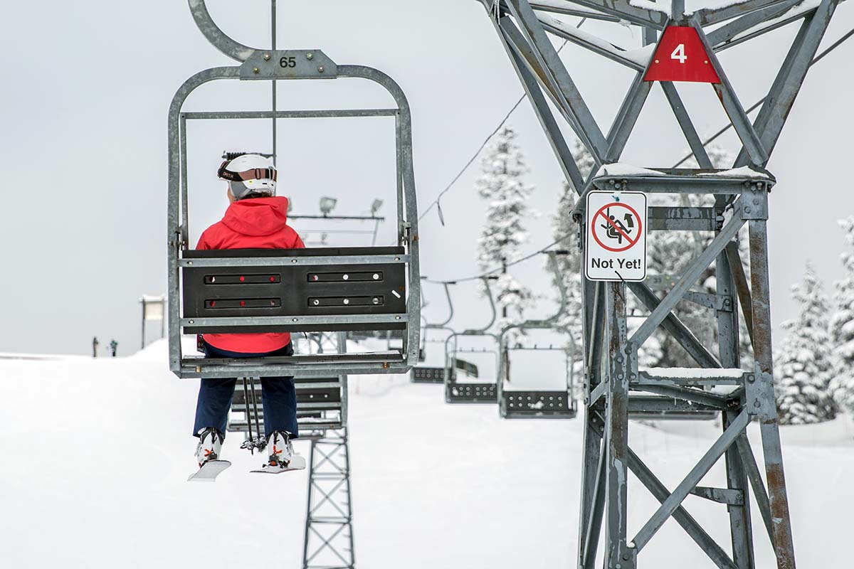 A woman in a red jacket on a chairlift