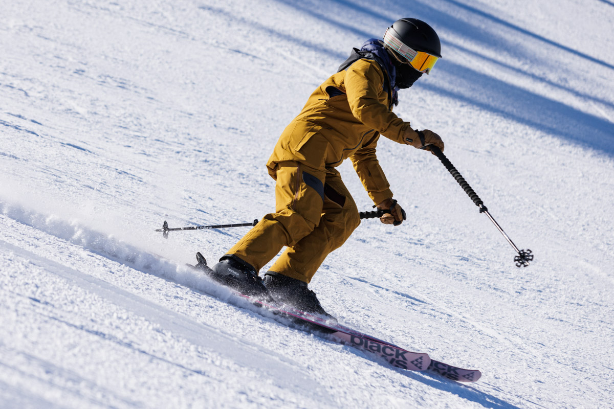A woman skiing down a steep slope in women's ski boots