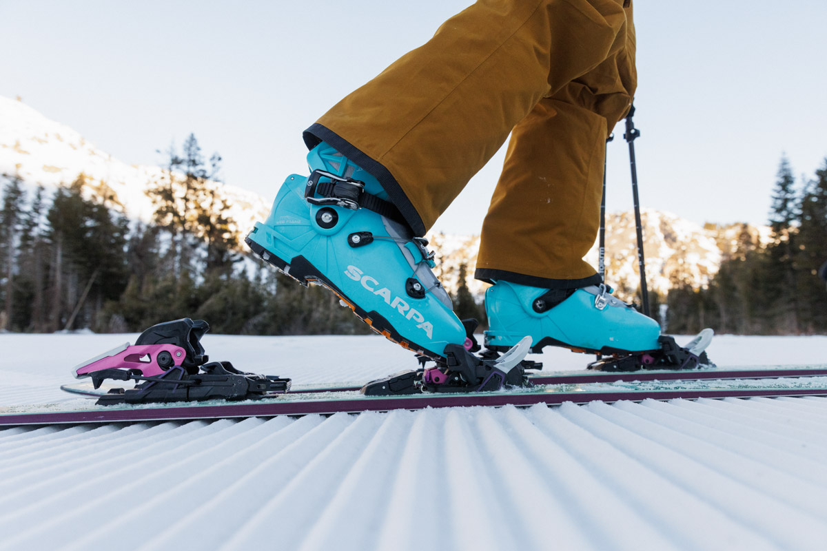 Blue women's ski boots on tech bindings