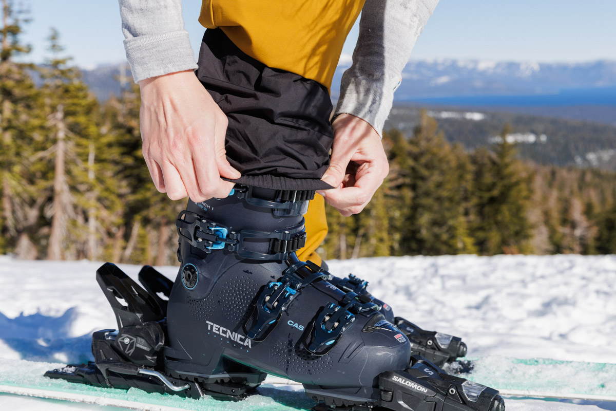 Pulling ski pants over a pair of women's ski boots