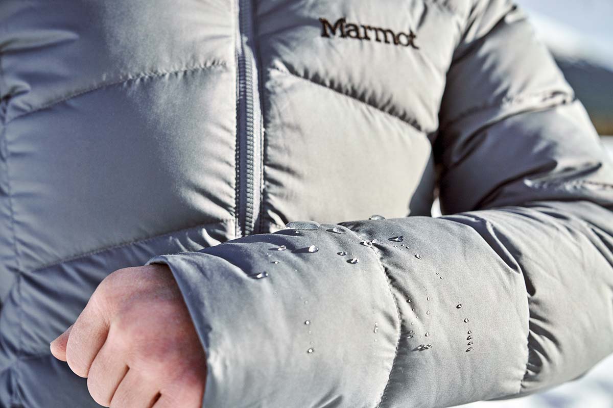 A close up of water droplets sitting on top of the sleeve of a down jacket without soaking in