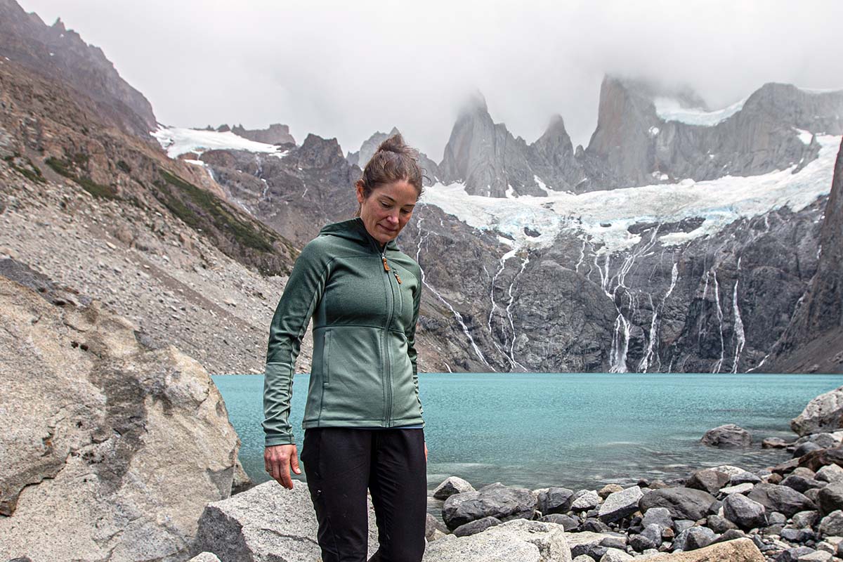 A woman wearing the Fjallraven Abisko Trail Fleece and hiking by a lake near Fitz Roy in Patagonia