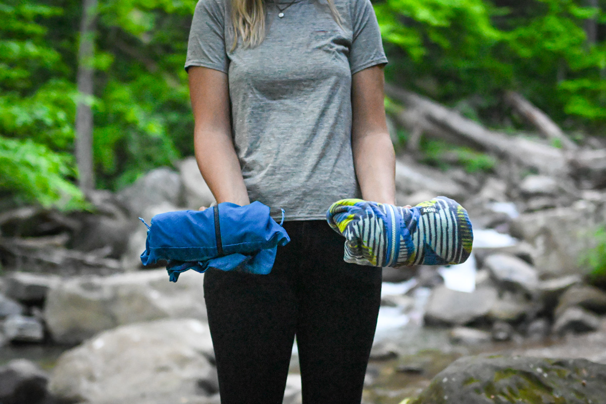 A woman holds up two fleece jackets side by side