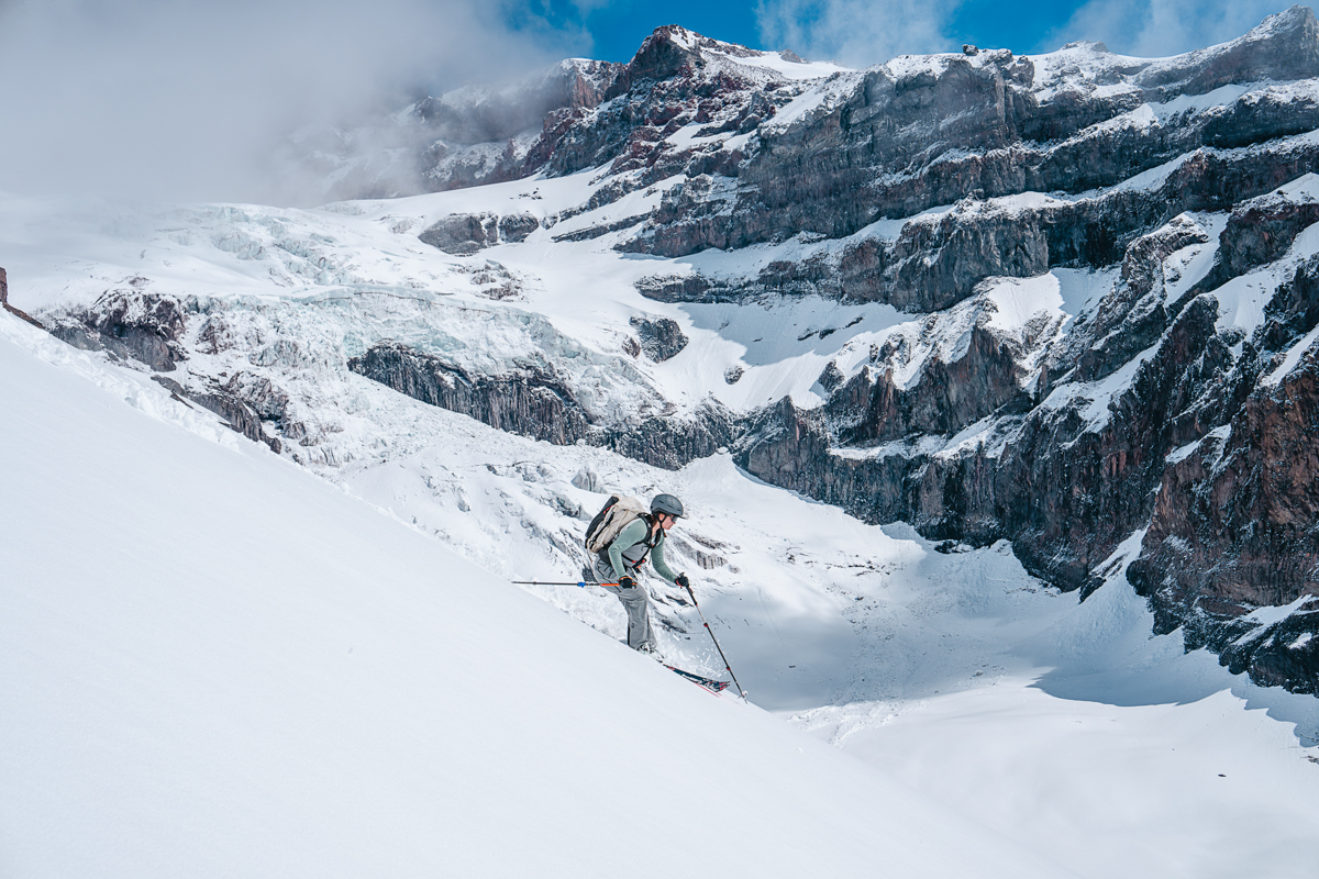 A woman skiing down a steep mountainous slope