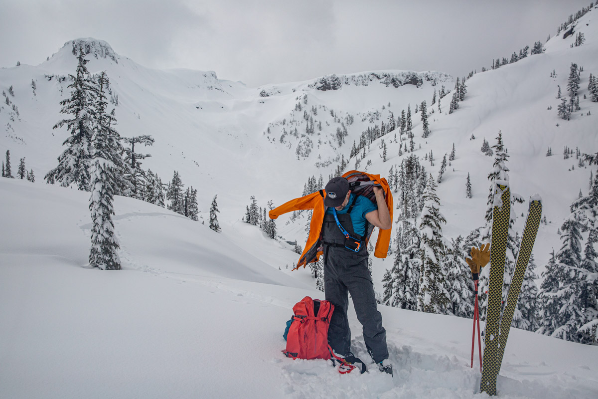 A man putting on a ski jacket