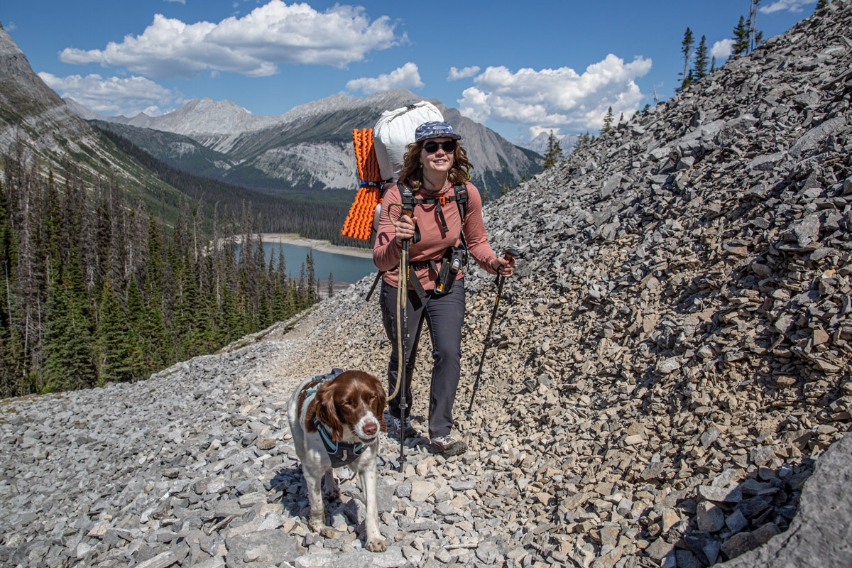 A woman hiking up a steep hill wearing a pink sun hoody