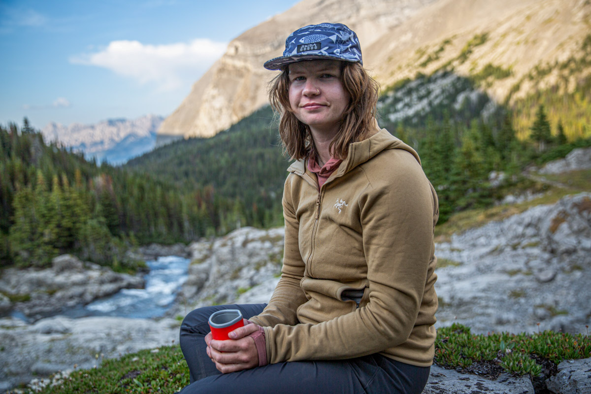 A woman smiling wearing a trail hat