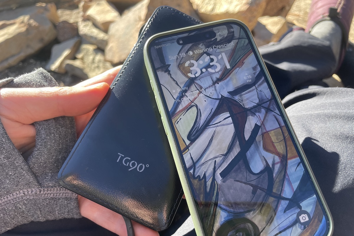 A phone and small charger resting in someones hands