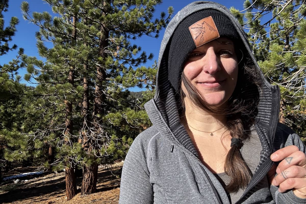 A women in a grey hoodie shows off the interior gridded fleece