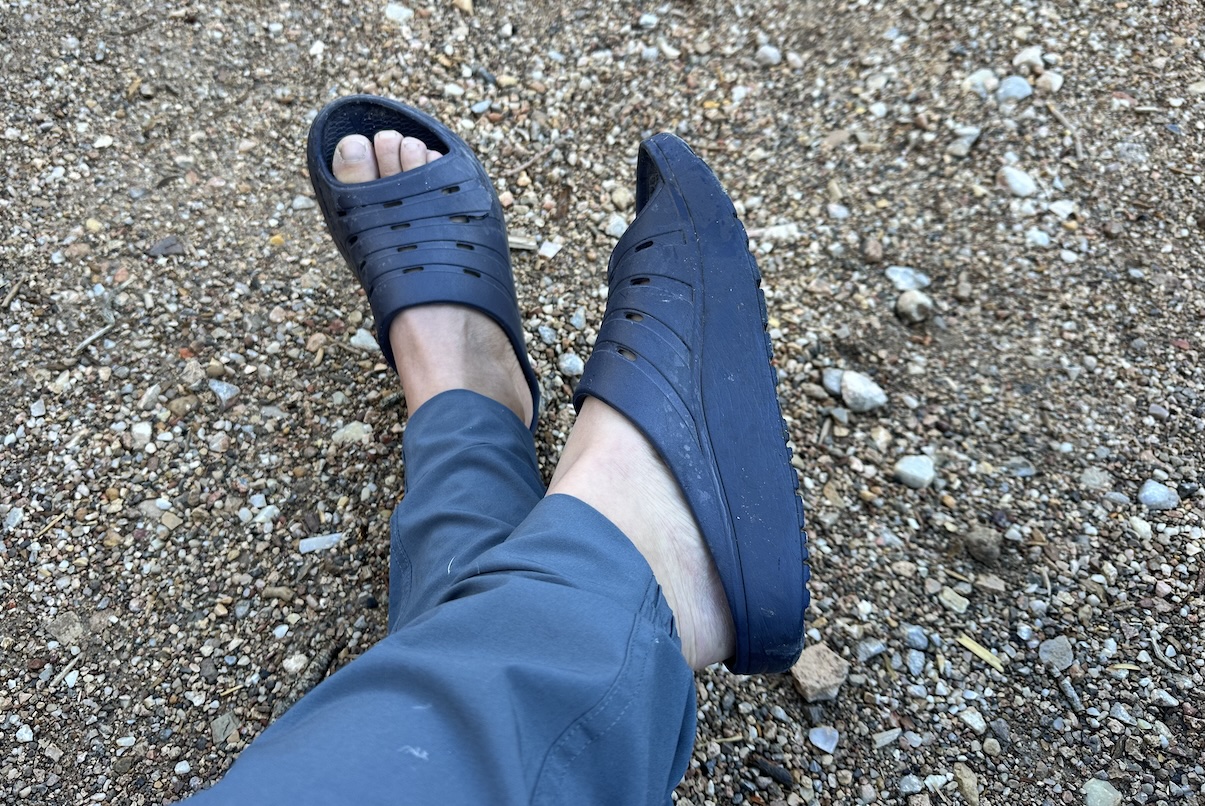 A woman's feet are shown in a pair of slide-on foam shoes for recovery after a race