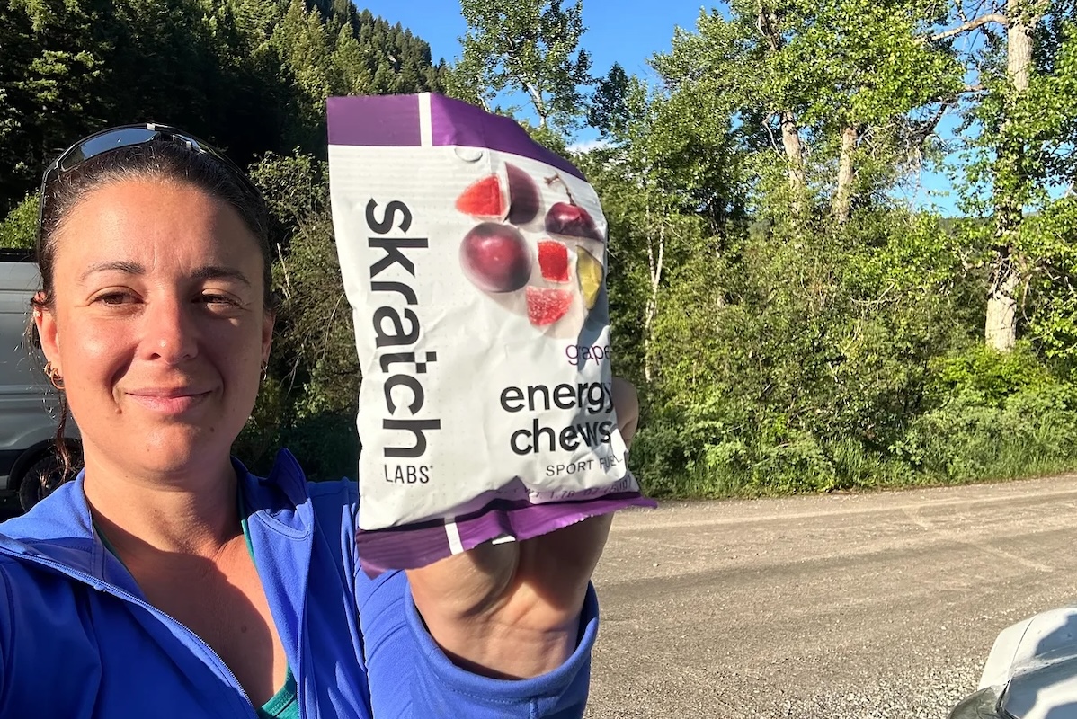 A woman holds out Skratch Labs energy chews as a good fueling option for running