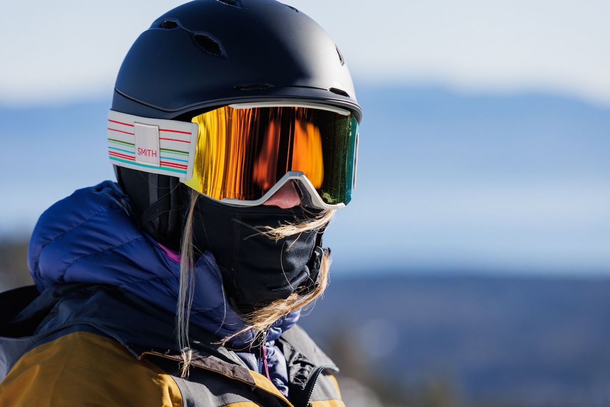 A closeupu of a woman wearing a ski helmet, goggles, and a neck gaiter