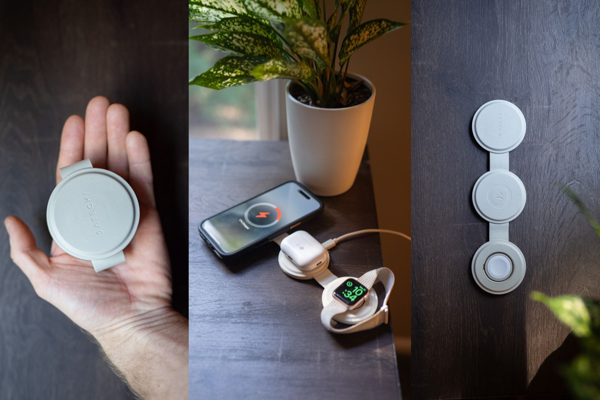 A hand holds a small, portable charging station.