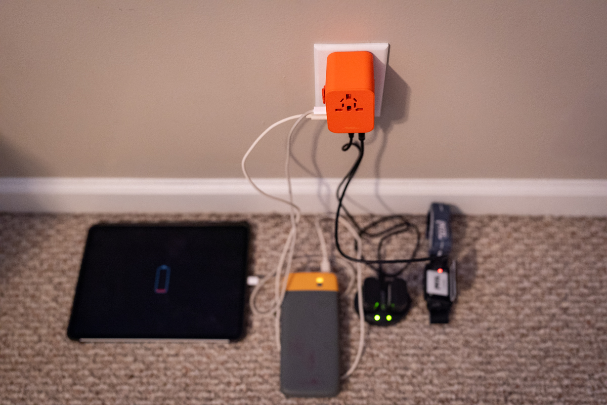 Five different gadgets are plugged into a wall charger.