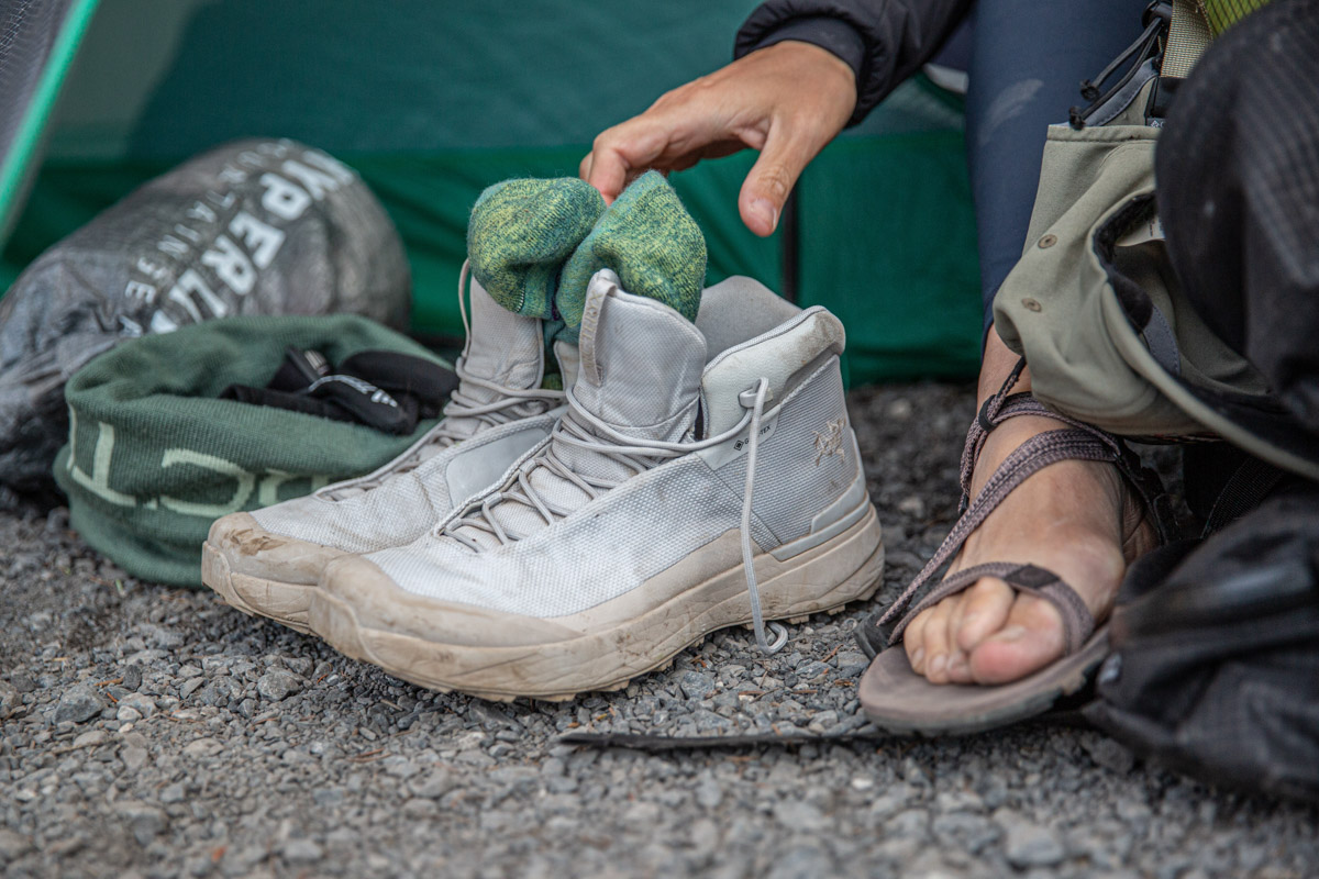 A pair of white hiking boots outside of a tent