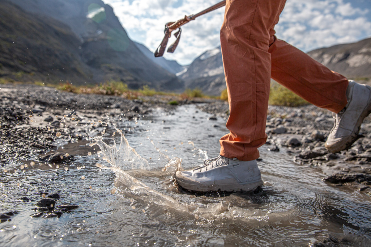 A white hiking boot splashing through a stream