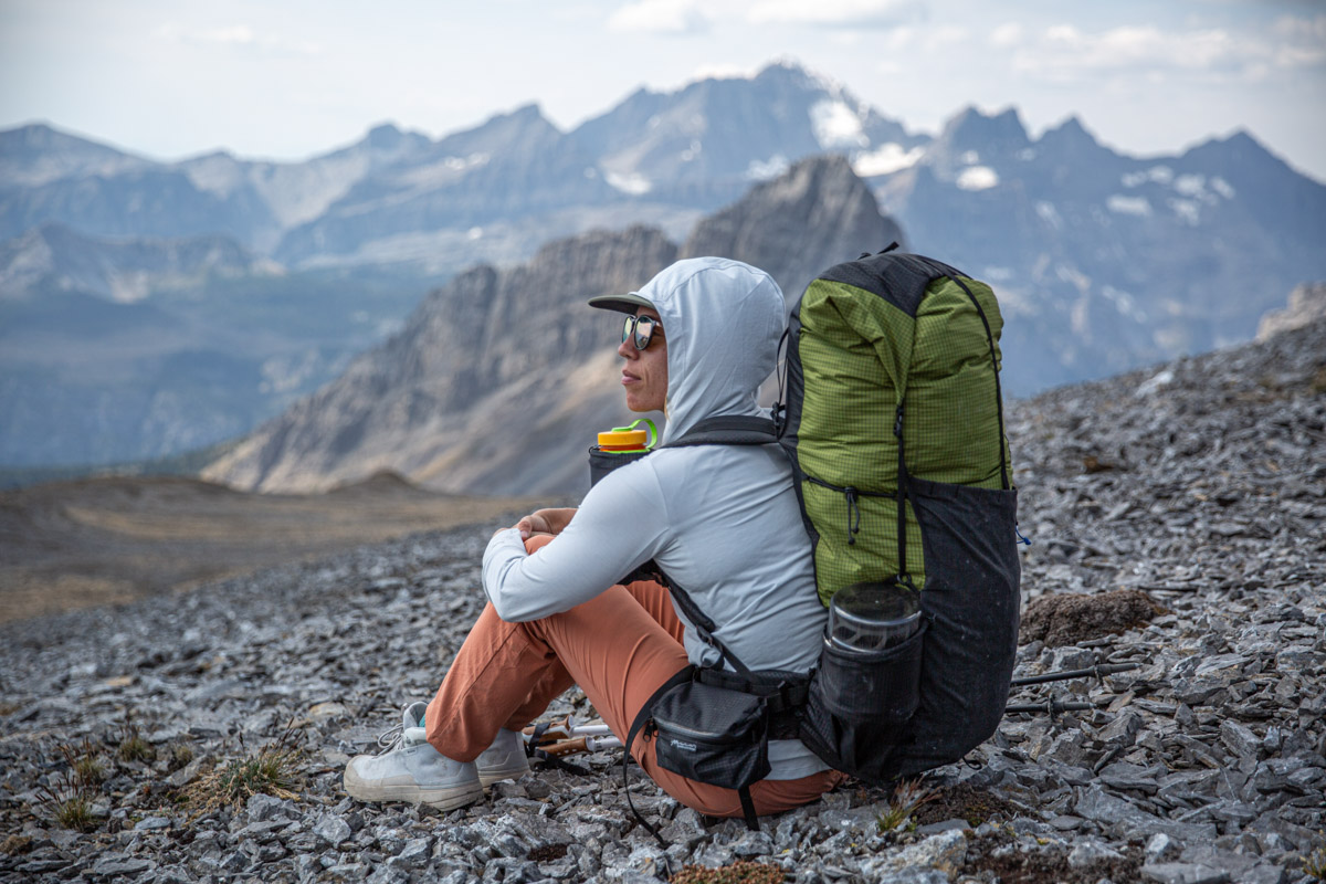 A woman sitting on the ground wearing white hiking boots