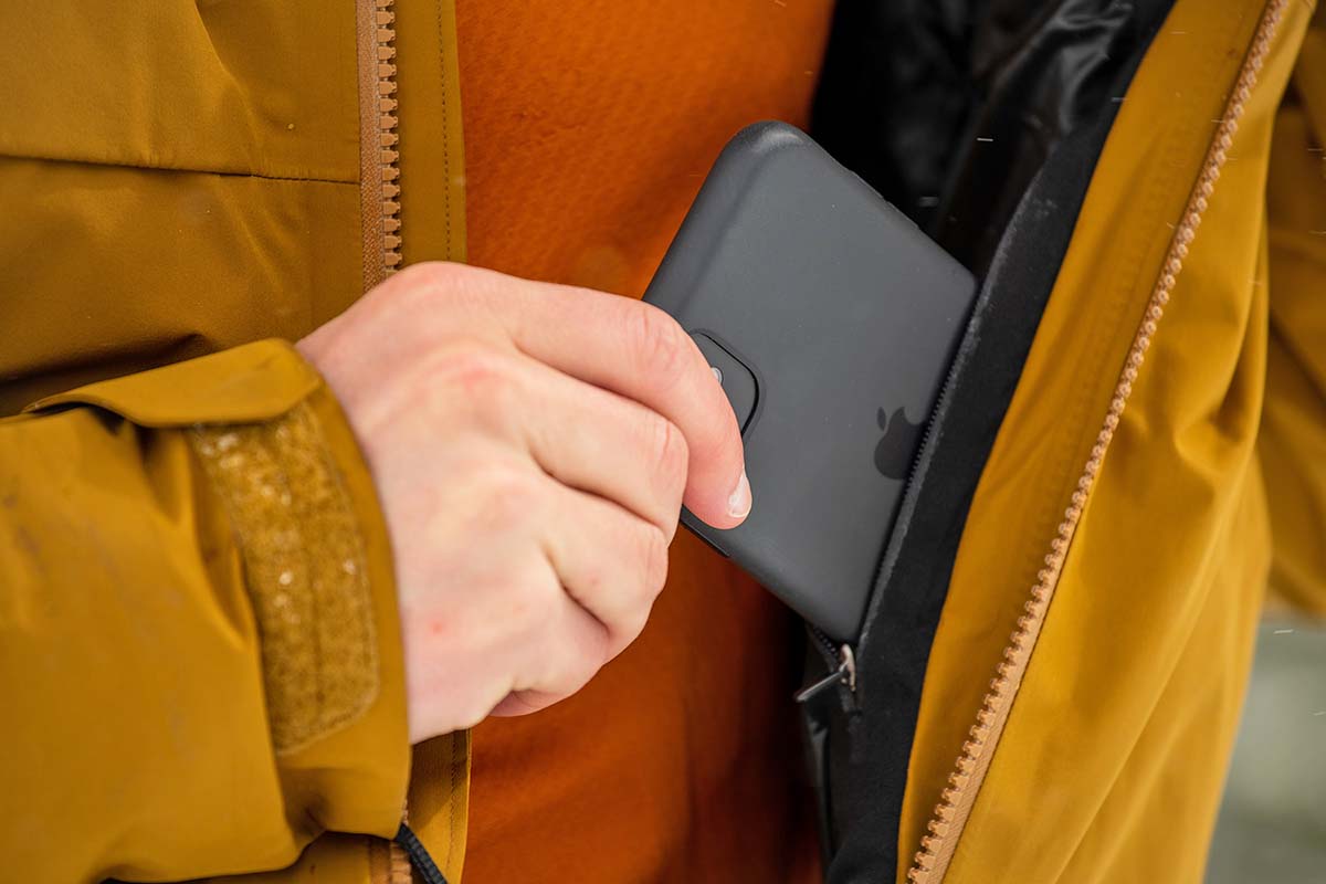 A tester fits a cell phone into the internal pocket on the left side of the Macai jacket.