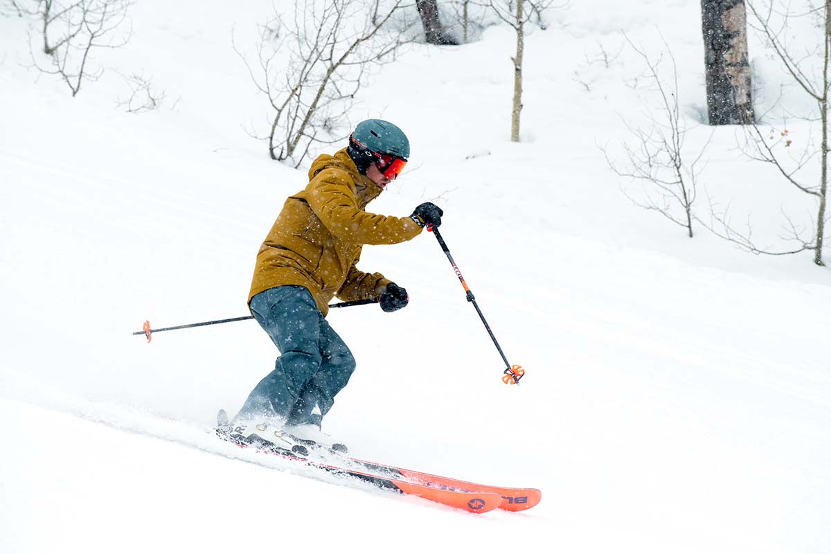 A skiier rides down a wintry, powdery slope in a resort.