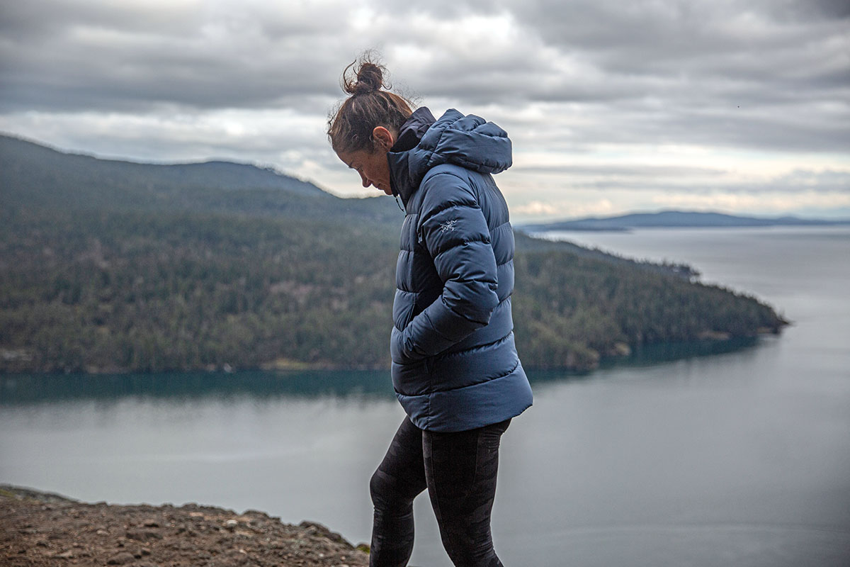 A woman hikes up a windy ridge in the Pacific Northwest in her Thorium jacket.