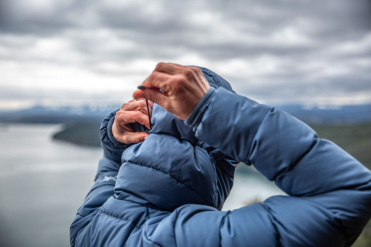 A woman adjusts the elastic on the back of her hood.