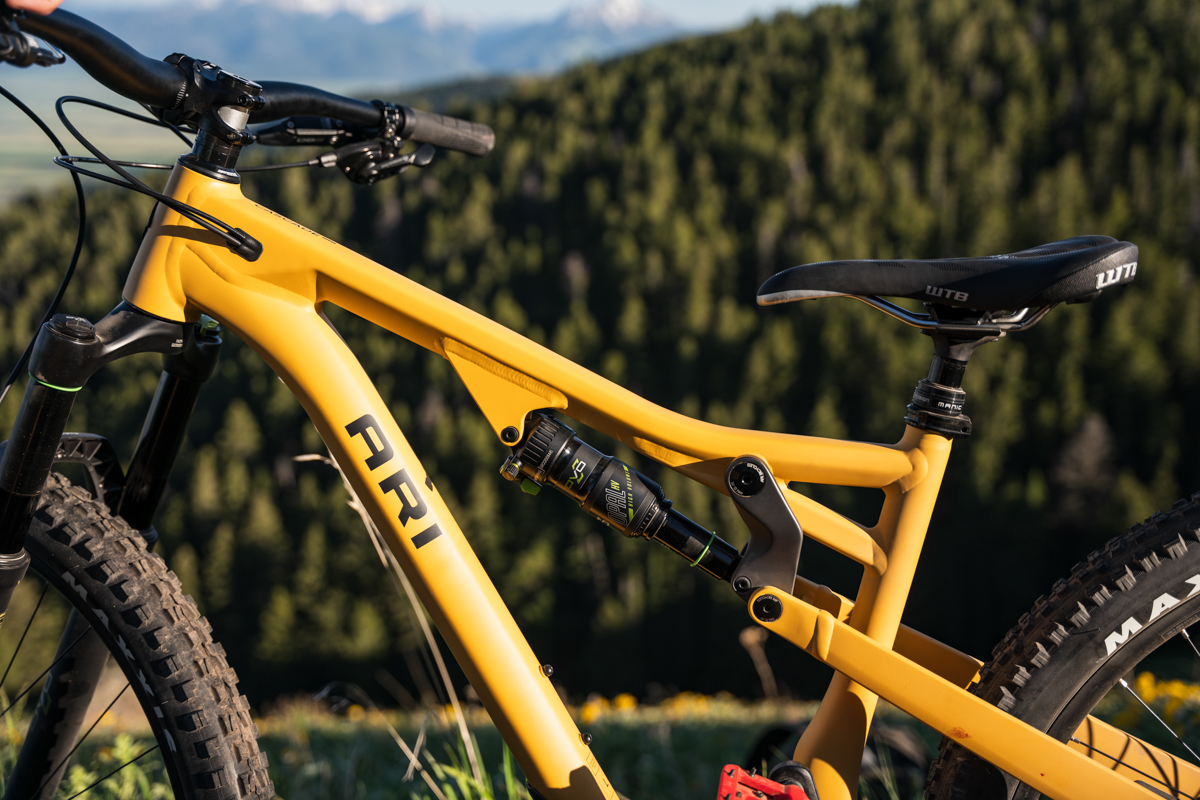 A close up of the suspension system on a yellow mountain bike