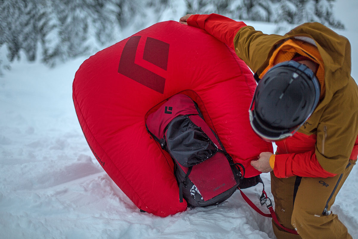 A man inspecting an inflated avalanche backpack