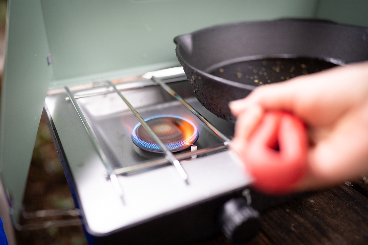 A close-up of a lit burner on a camping stove