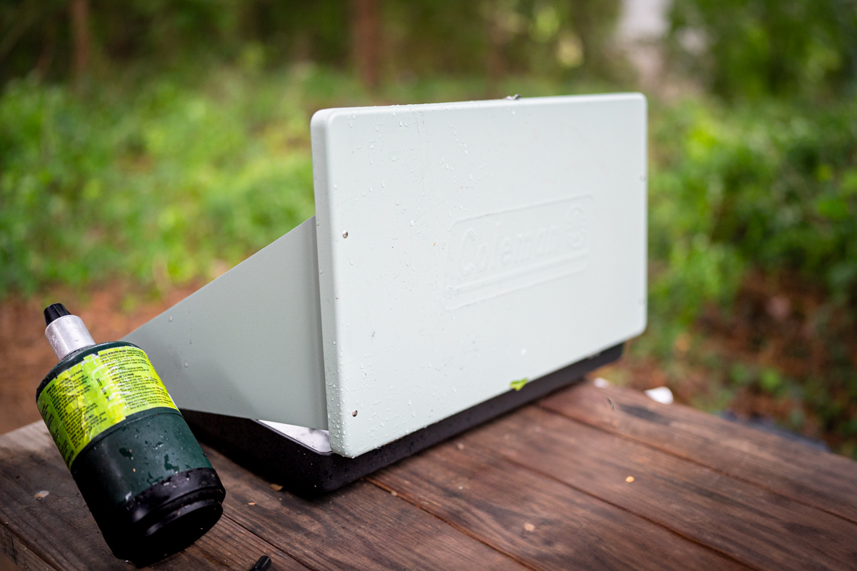 The Coleman Cascade Classic stove seen from behind with the wind flaps up and fuel bottle attached