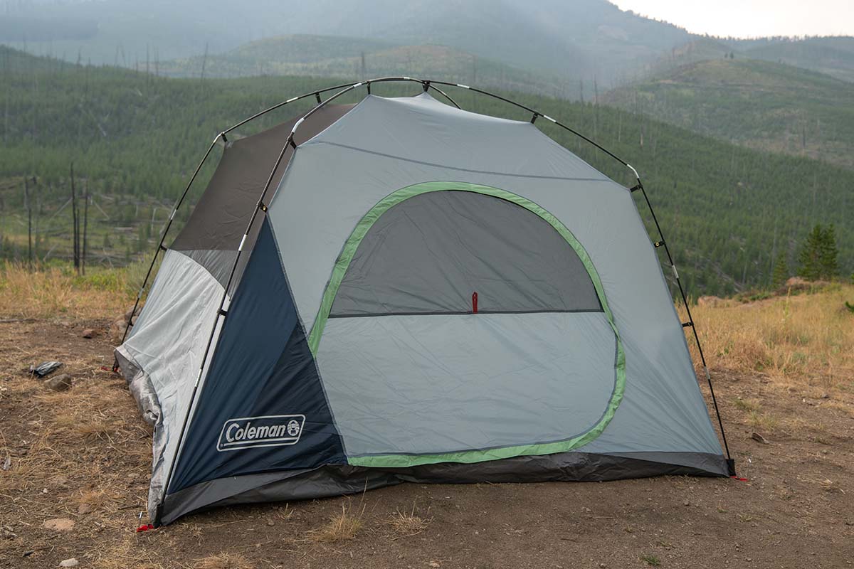 The Coleman Skydome tent pitched in a dirt and grass field.